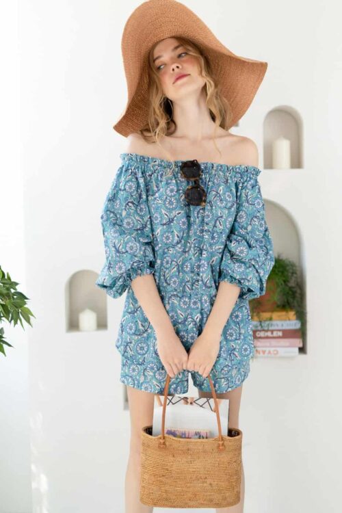 Women wearing a blue off-shoulder dress with a wide-brim straw hat and sunglasses.