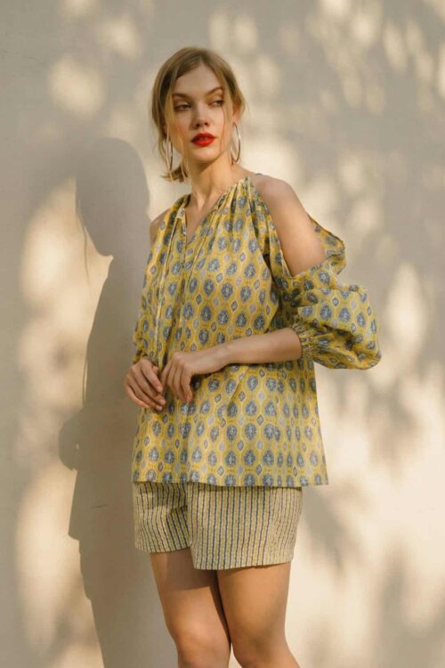 Summer fashion outfit with a patterned blouse and striped shorts.