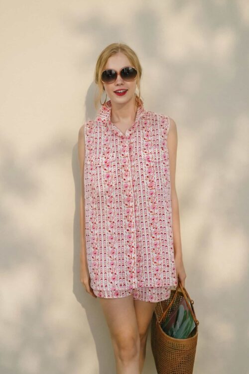 Cute woman in pink patterned sleeveless dress with sunglasses.