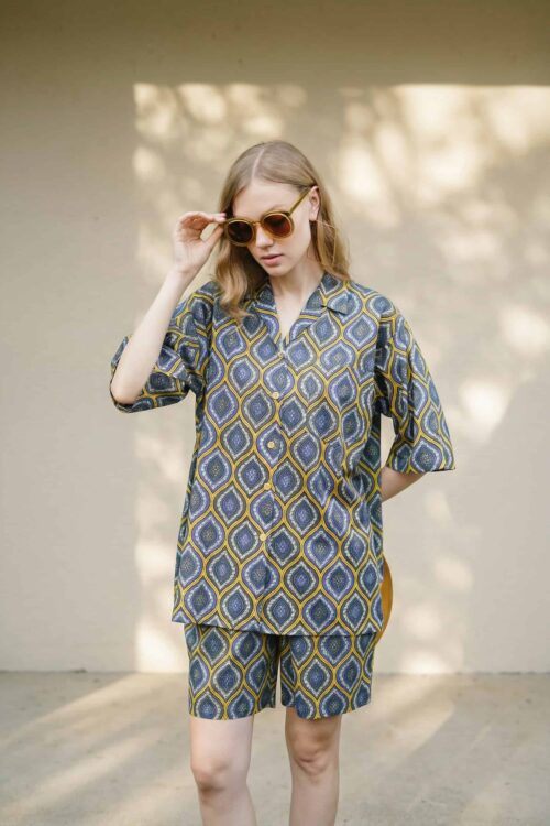 Woman wearing a stylish patterned Coco lounge set with sunglasses outdoors.