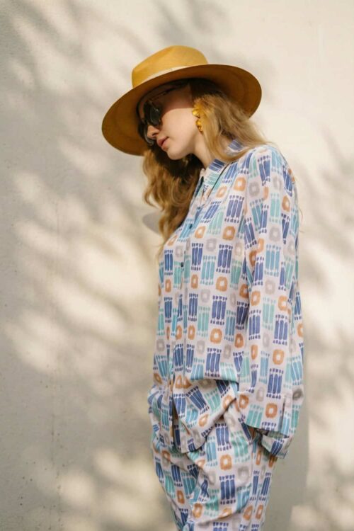 Stylish woman wearing a patterned outfit with a wide-brim hat and sunglasses, inspired by truffle to.