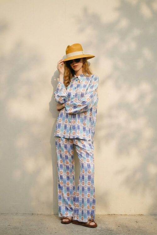 Elegant woman wearing a patterned outfit inspired by truffles, accessorized with a wide-brimmed hat.