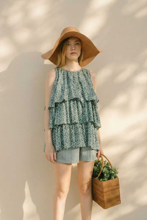 Woman in Peony-themed summer dress with wide-brim hat and basket.