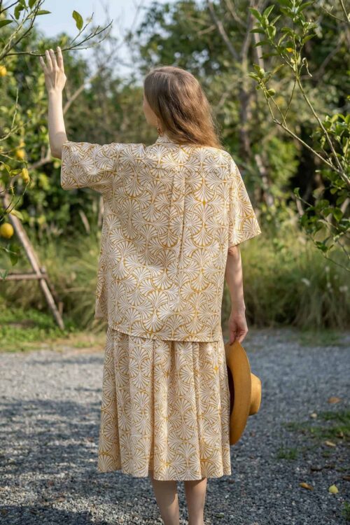 Lucky woman reaching out to lemon trees in a sunny orchard.