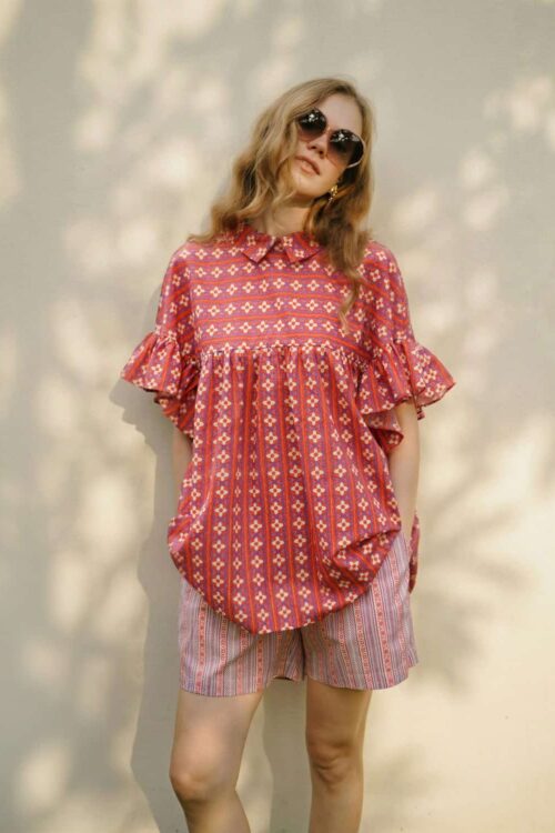 Sweet boho summer dress with ruffled sleeves paired with colorful striped shorts for a casual, styli.