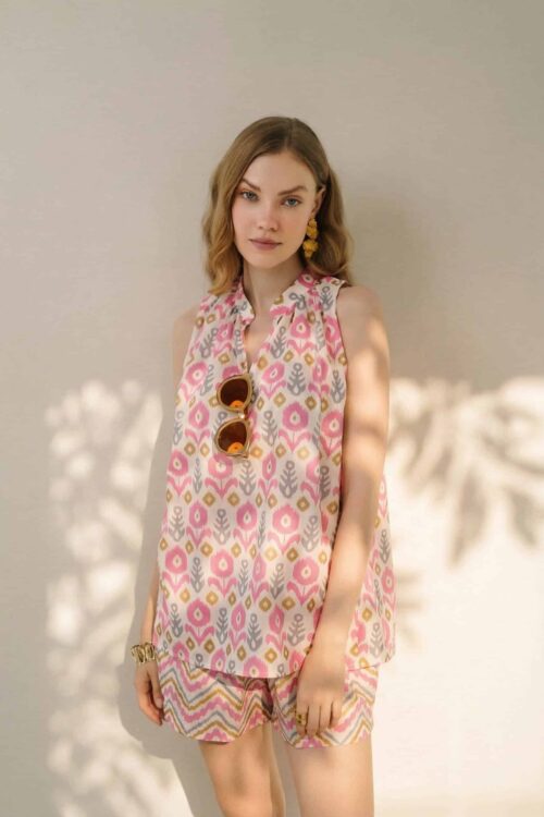 Stylish woman wearing a colorful honey-inspired outfit with sunglasses and jewelry.